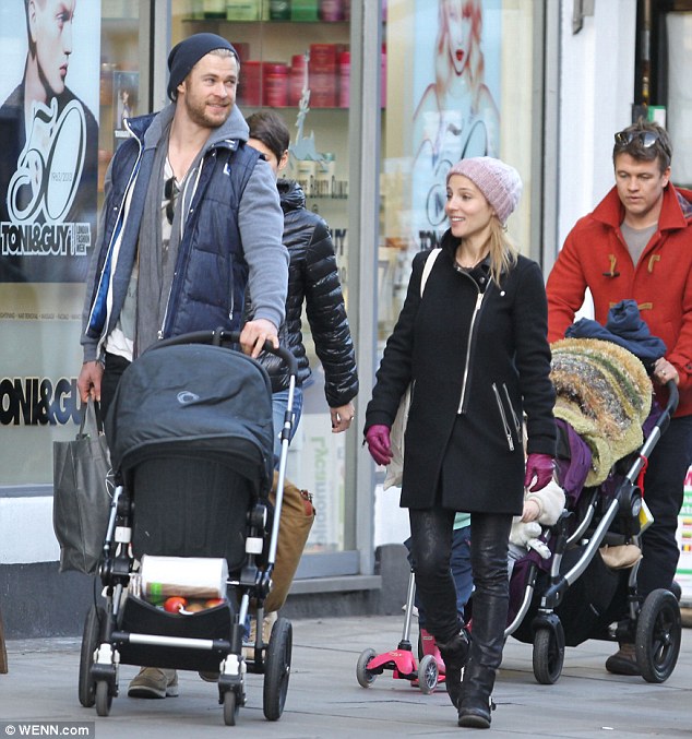 On dad duties: Chris Hemsworth trades his hammer for the pram as he enjoys a day out with wife Elsa Pataky and their daughter India Rose